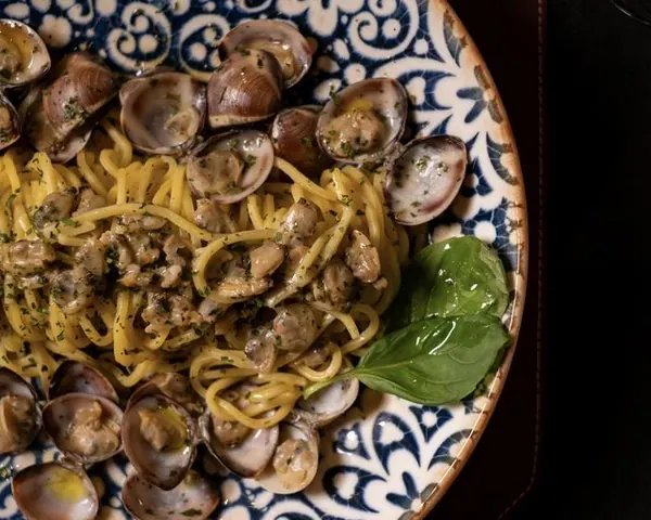 Bavette alle vongole con basilico su un piatto decorato – Il Mastino Bistrot, Verona